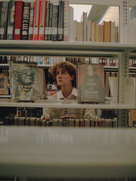 man behind books in library