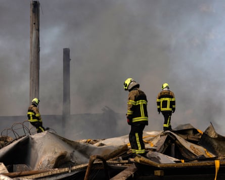Ukrainian firefighters work to put out a fire following a massive Russian ballistic missile and drone strike on Kyiv.