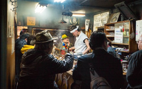 Customers crammed inside a smoked-filled old eel bar.