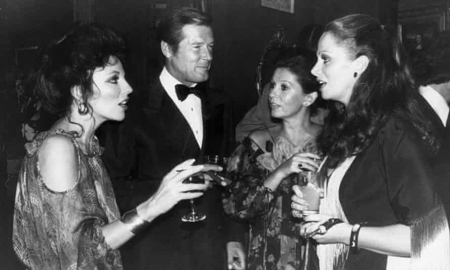 Stud Party 27th September 1977: British actress Joan Collins, writer Jackie Collins, actor Roger Moore and his wife Luisa Mattioli at a party celebrating the release of ‘The Stud’, a film based on a novel by her sister.