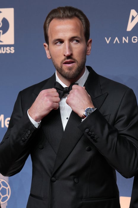 Harry Kane, in a black tuxedo, adjusts his bow tie at the Ballon d'Or ceremony