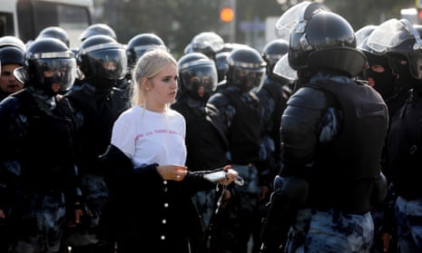 A woman is held by riot police at a rally in Pushkinskaya Square in Moscow on 3 August.
