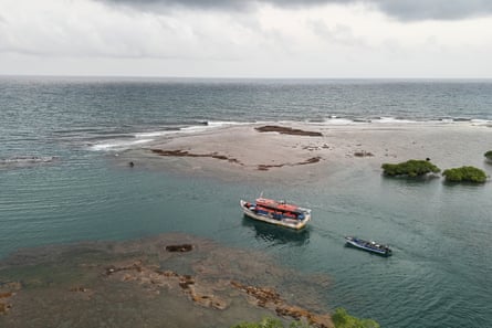 a boat towing a small launch sets out to sea