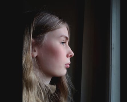 A girl looking to the right out of a window