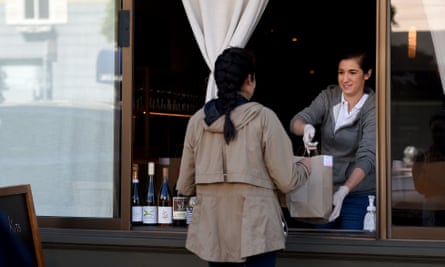 An employee for Atelier Crenn restaurant hands a takeout order to a customer in San Francisco, California.