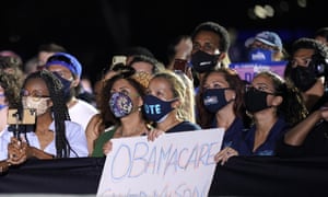 People listen as Barack Obama speaks at a rally for Joe Biden on Monday in Miami.
