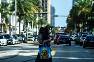 A woman wears a mask as she walks in Miami Beach, Florida on Thursday.