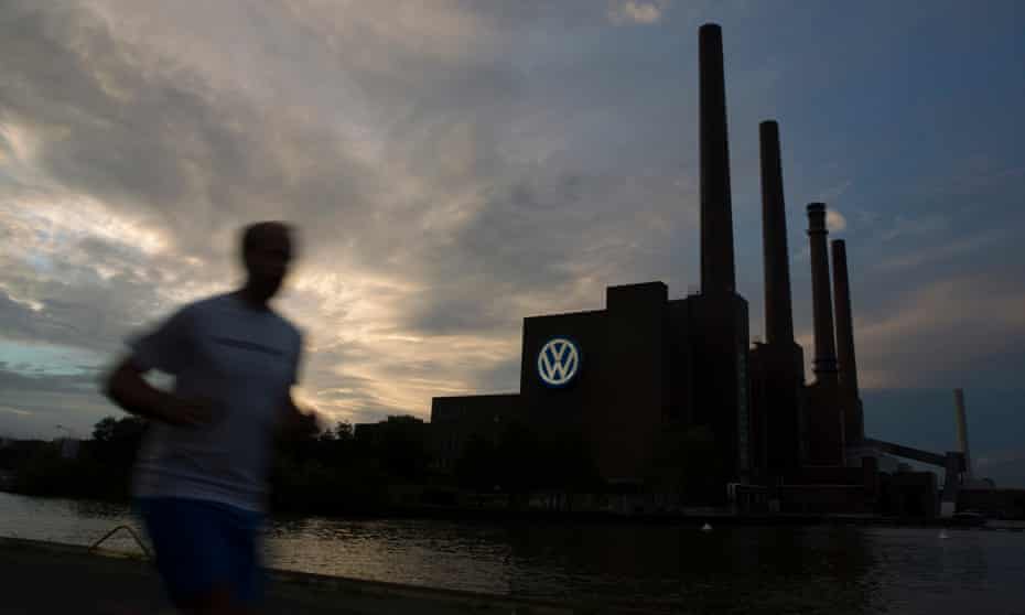 A jogger runs past the Volkswagen power plant in Wolfsburg, Germany
