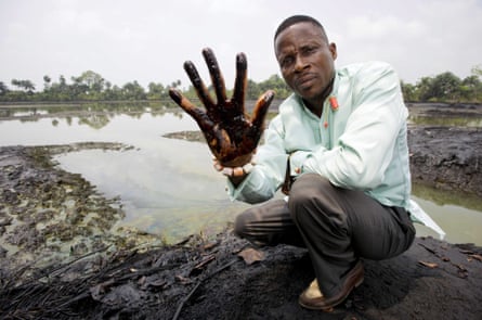 Eric Dooh showing his hand covered with oil from a creek near Goi, Ogoniland, Nigeria. (inline)