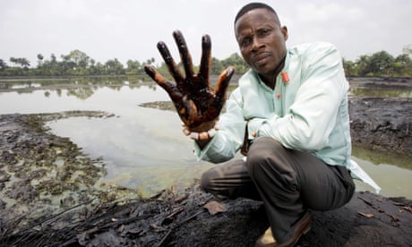 Eric Dooh showing his hand covered with oil from a creek near Goi, Ogoniland, Nigeria.