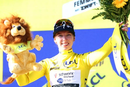 Lorena Wiebes celebrates on the podium wearing the yellow jersey