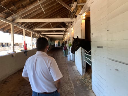 Chaplain Joseph Del Rosario walks in a stable in Churchill Downs.