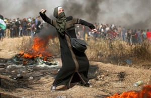 A girl hurls stones during clashes with Israeli troops at the border between Israel and Gaza.