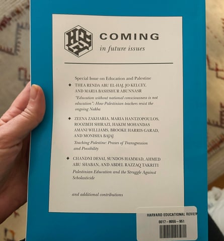 hand holds blue and white book