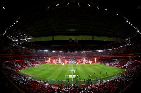 A pyrotechnics display alongside fans holding up red and white cards as the players take to the pitch for the Premier League match between Arsenal and Liverpool at Emirates Stadium.