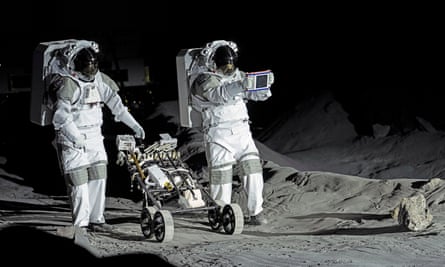 Two suited astronaunts on a moon surface simulator.