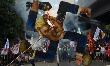 Protesters burn an effigy of Donald Trump at a march in Manila.