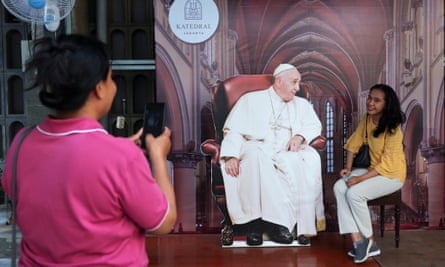 A person poses with a cutout depicting Pope Francis at Jakarta cathedral