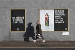 A woman walks past posters about the climate crisis