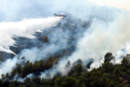 A firefighting plane makes a drop amid efforts to battle a wildfire in Artana, Spain.