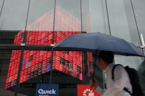 A man walks in front of an electronic quotation board displaying the Nikkei 225 stock prices on the Tokyo Stock Exchange in Tokyo on June 15, 2026.