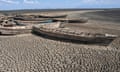 Stationary engineless boats lie idle on a dry inland lake in Africa