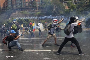 Anti-government protesters work together to aim a giant slingshot at security forces blocking their march from reaching the Supreme Court in Caracas, Venezuela,on 10 May during protests over high crime, sky-high inflation and shortages of food and medicine