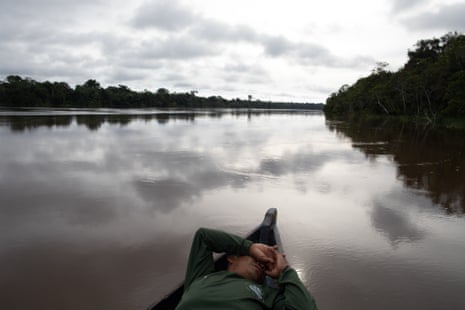 An EVU recruit lies in the prow of a boat on a river.
