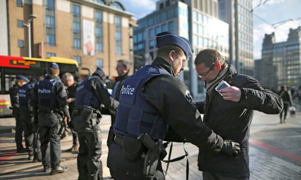 A man is searched in Brussels following the bomb attacks.