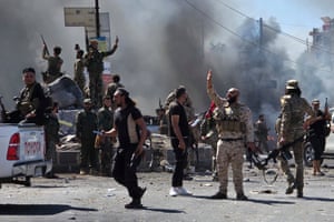 Chaotic street scene with military personnel moving around and holding up guns amid rising smoke