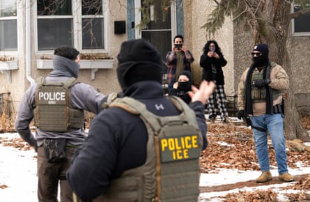 civilians film federal agents on a street outside