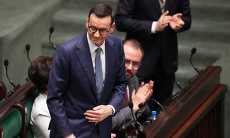 Mateusz Morawiecki stands as people applaud on the day he presents his government’s programme and asks parliament for a vote of confidence