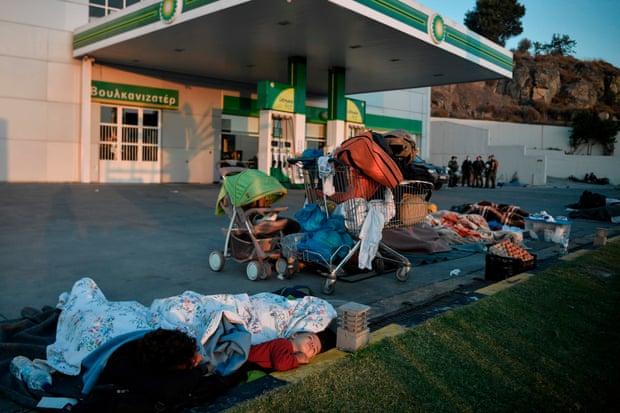 Homeless refugees sleep at a fuel station, Moria