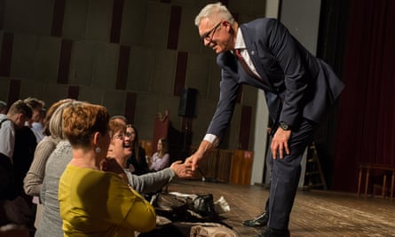 Ivan Korčok shaking hands with a woman while stood on a stage