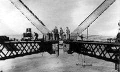 Workers stand atop the Sydney Harbour Bridge during the joining of the two arches.