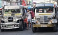 A 'barker' (C), a person who calls passengers to ride jeepneys, guides drivers along a street in Manila.