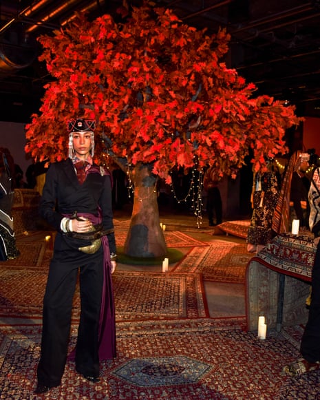 Female model on a Persian carpet in front of a red tree