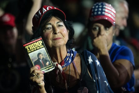a woman holds a trump book