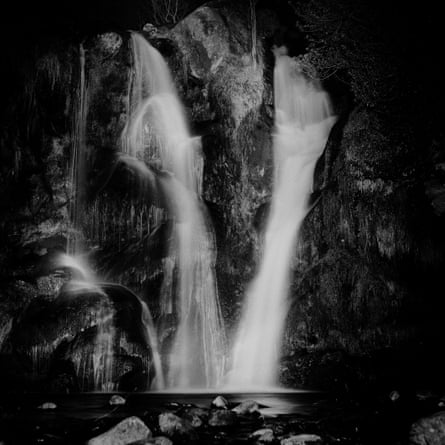 Two waterfalls flowing into almost the same point on the water below.
