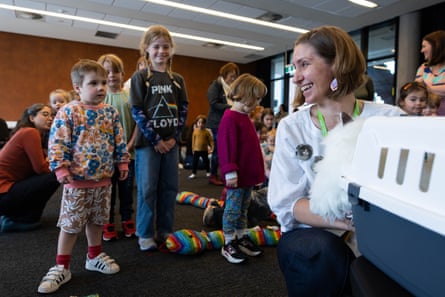Elissa removes a cat from its carrier as kids line up to meet the furry animatrons