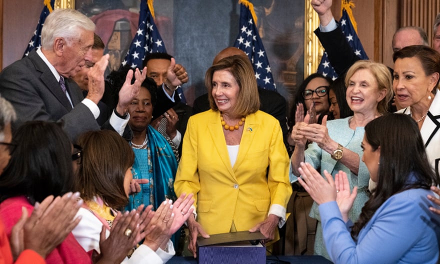 Democrats applaud after Nancy Pelosi signs the Inflation Reduction Act, which includes climate protections, among other measures.