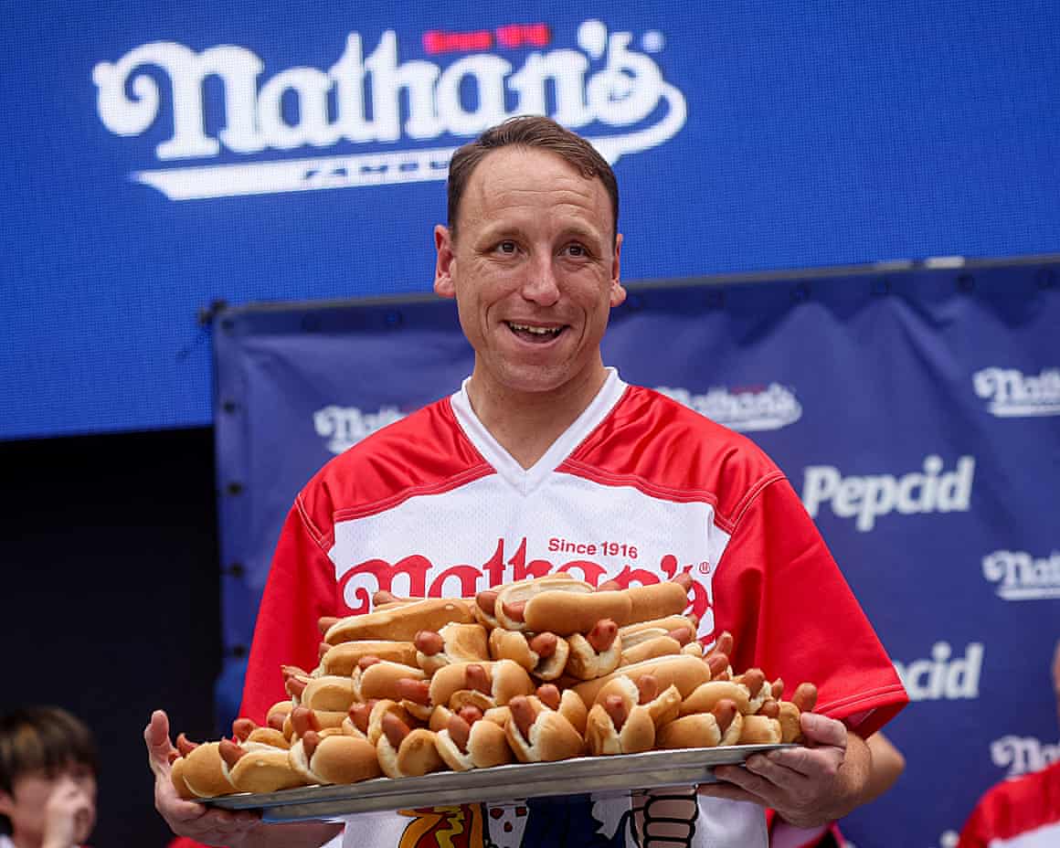 Man in red shift with hotdogs on tray