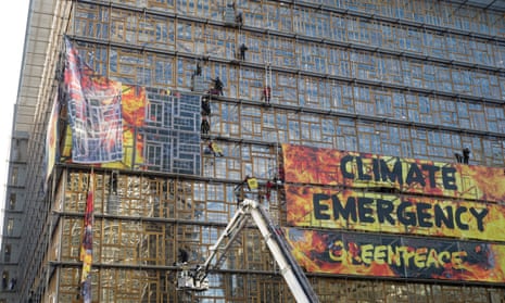 Firefighters and police remove the Greenpeace placard from the Europa building in Brussels, Belgium.