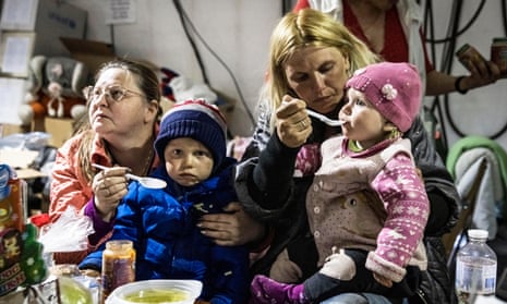 Women and children eat and drink at a food tent in Zaporizhzhia catering for evacuees who arrived from Mariupol.