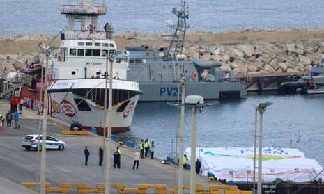 The boat of NGOs Open Arms and World Central Kitchen, with UAE aid loaded on a barge (R), docked at Larnaca harbour in Cyprus.