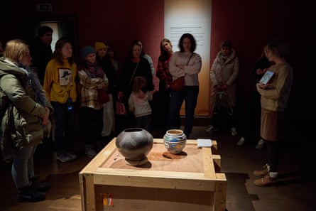 People gathered around two vases on a crate