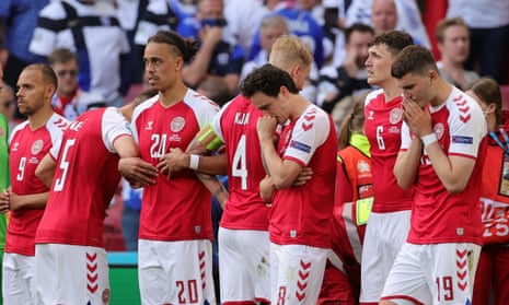 Denmark players provide a shield for Christian Eriksen as he receives medical treatment on the pitch.