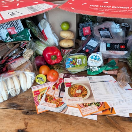 صندوقان من جستو مفتوحان على سطح طاولة مع مكونات الطعام الطازجة واللحوم منتشرة ومرتبة مع مجموعة متنوعة من بطاقات الوصفات.