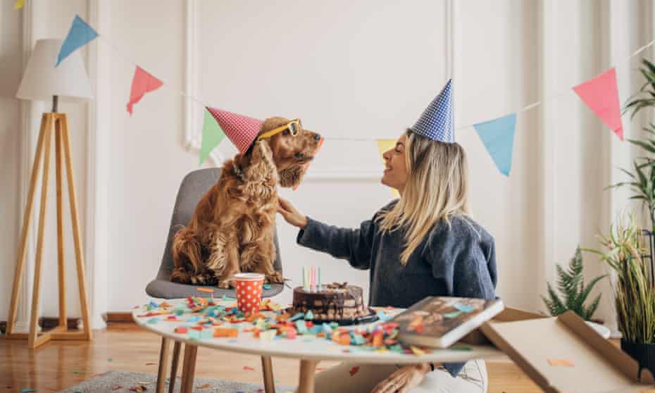 A woman celebrating her dog's birthday with her dog (Posed by a model)