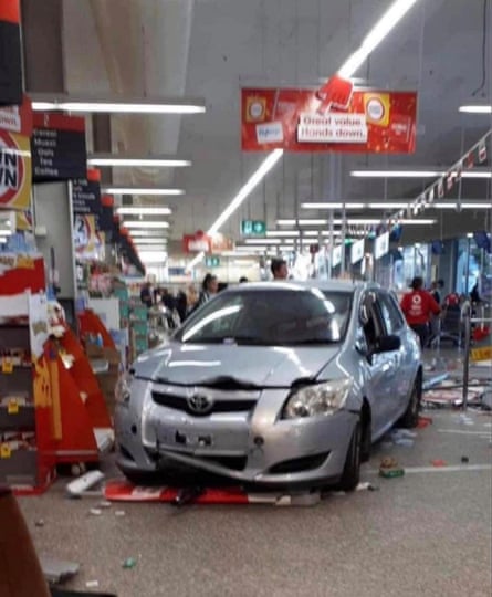 A Toyota Corolla stopped inside the Coles branch, surrounded by debris